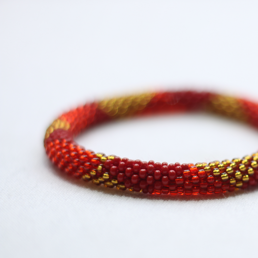 ROLL-ON PERLEARMBÅND FRA NEPAL - Blank rød med gyldne og røde perler
